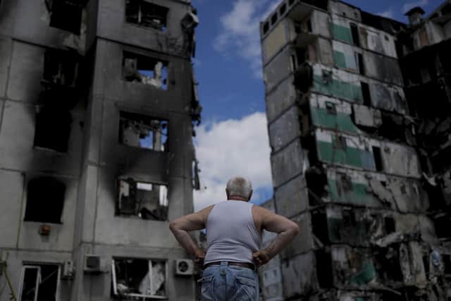 A man stands looking at a building destroyed during attacks, in Borodyanka, on the outskirts of Kyiv, Ukraine, on Saturday