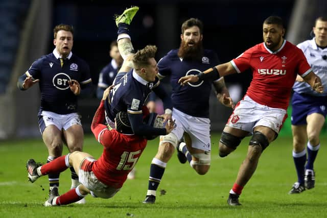 Darcy Graham feels the full force of a tackle by Wales full-back Leigh Halfpenny. Picture: Jane Barlow/PA