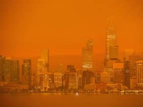 The San Francisco skyline is obscured in orange smoke.