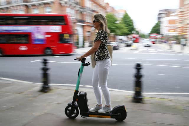 An e-scooter user in London, where they can be ridden in public legally under a rental scheme - but not on pavements