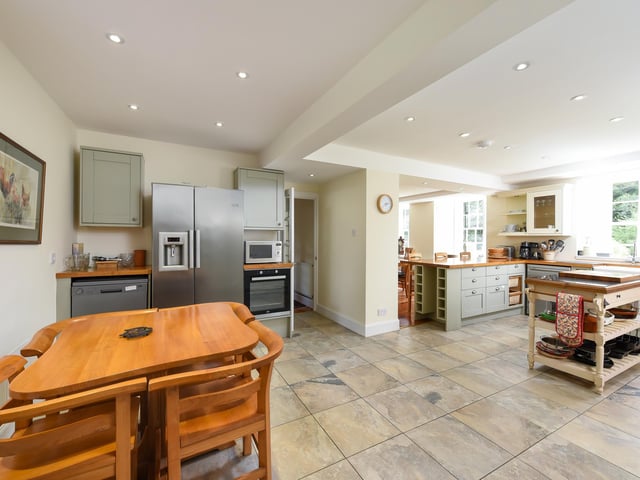 To the front of the ground floor are a south-facing lounge and a dining room, both with large fireplaces.
A generously-proportioned open-plan kitchen and dining space is to the rear of the house, and features an Aga range and breakfast bar.
A sweeping staircase leads to five bedrooms upstairs, all of which have been thoughfully finished to an exceptionally standard.
The principal bedroom features a fireplace and an ensuite with a free-standing bath and shower.