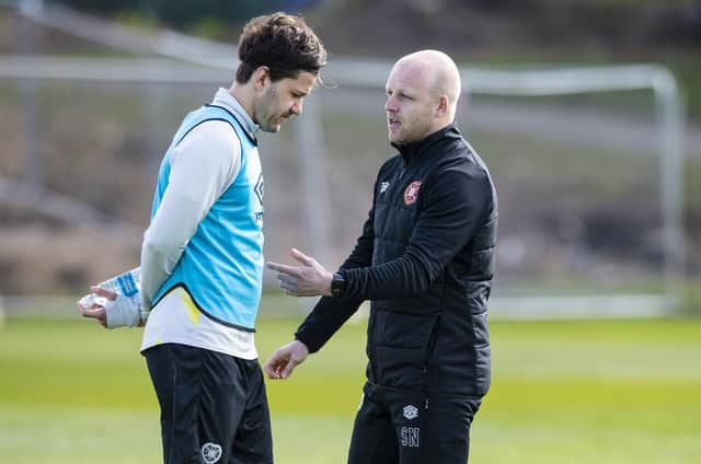 Hearts manager Steven Naismith speaks to Peter Haring during a training session.