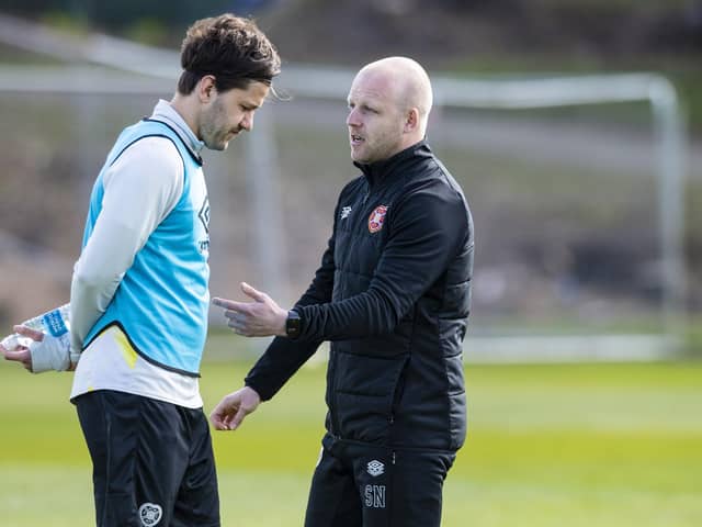 Hearts manager Steven Naismith speaks to Peter Haring during a training session.