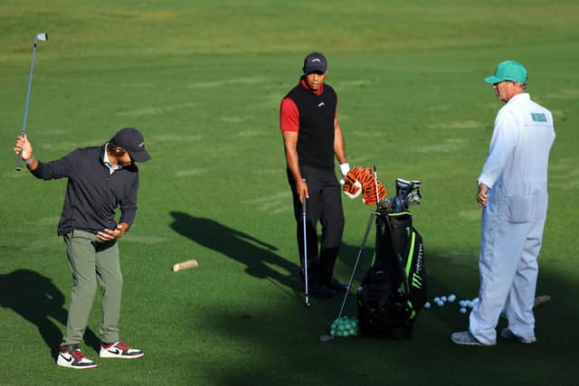 Charlie Woods gives his dad Tiger som swing advice before heading out in the final round of the 88th Masters at Augusta National Golf Club. Picture: Andrew Redington/Getty Images.