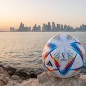 An official FIFA World Cup Qatar 2022 ball sits on display in front of the skyline of Doha.