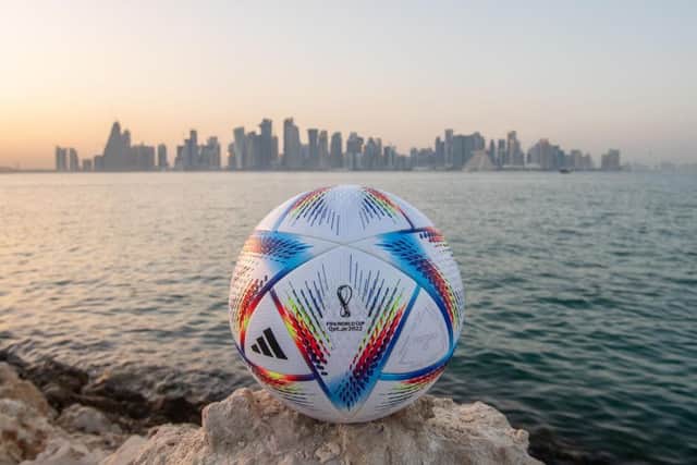 An official FIFA World Cup Qatar 2022 ball sits on display in front of the skyline of Doha.
