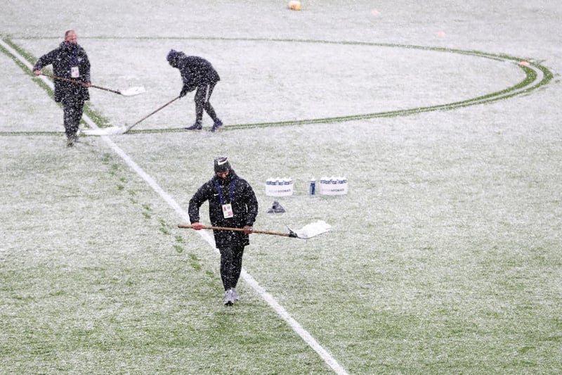 Staff can be seen here clearing the snow inside the stadium ahead of The Emirates FA Cup Fourth Round match between Chelsea and Luton Town at Stamford Bridge.