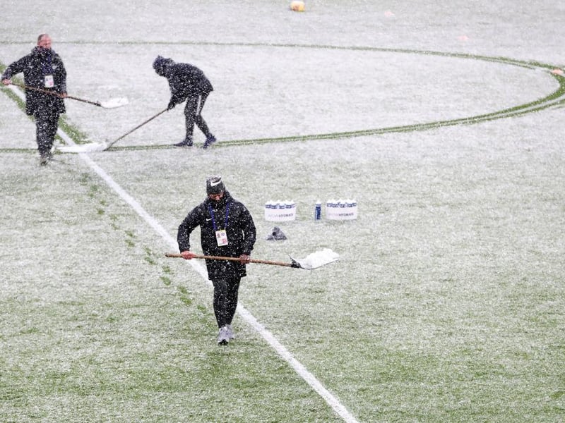 Staff can be seen here clearing the snow inside the stadium ahead of The Emirates FA Cup Fourth Round match between Chelsea and Luton Town at Stamford Bridge.