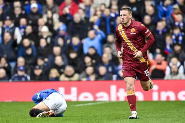 Rangers' Ross McCausland (L) is down injured after a tackle from Motherwell's Dan Casey (R).