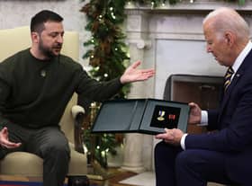 President of Ukraine Volodymyr Zelensky presents a medal from a Ukrainian soldier to U.S. President Joe Biden during a meeting in the Oval Office of the White House
