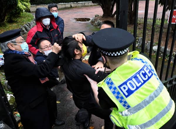 Police try to pull a Hong Kong pro-democracy protester out of the grounds of the Chinese consulate in Manchester (Picture: Matthew Leung/The Chaser News/AFP via Getty Images)