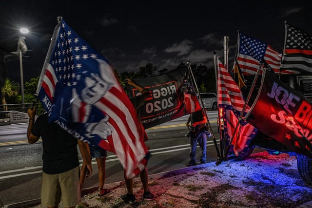Supporters of former US President Donald Trump stand outside his residence in Mar-A-Lago, Florida on August 8, 2022. Several boxes were taken away, asource said, adding that no doors were kicked down and that the raid had concluded by the late afternoon.