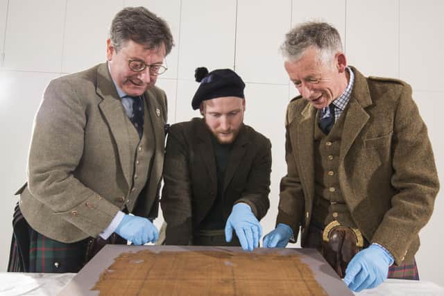 John McLeish, chair of the Scottish Tartans authority, V&A Dundee curator James Wylie and tartan historian Peter MacDonald have a close look at the Glen Affric tartan. Picture: Alan Richardson