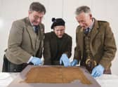 John McLeish, chair of the Scottish Tartans authority, V&A Dundee curator James Wylie and tartan historian Peter MacDonald have a close look at the Glen Affric tartan. Picture: Alan Richardson