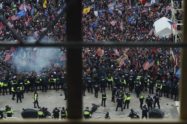 Police hold back supporters of US President Donald Trump as they gather outside the US Capitol's Rotunda on January 6, 2021, in Washington, DC. - Demonstrators breached security and entered the Capitol as Congress debated the a 2020 presidential election Electoral Vote Certification. (Photo by Olivier DOULIERY / AFP)