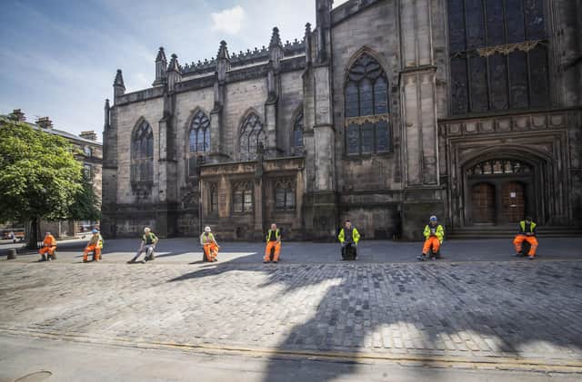 Construction workers comply with social distancing during their break along Edinburgh's Royal Mile.
