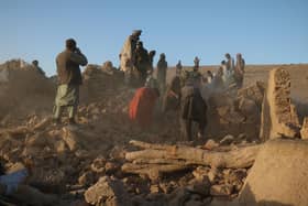 Afghan residents clear debris from a damaged house after earthquake in Sarbuland village of Zendeh Jan district of Herat province (Photo by Mohsen KARIMI / AFP) (Photo by MOHSEN KARIMI/AFP via Getty Images)