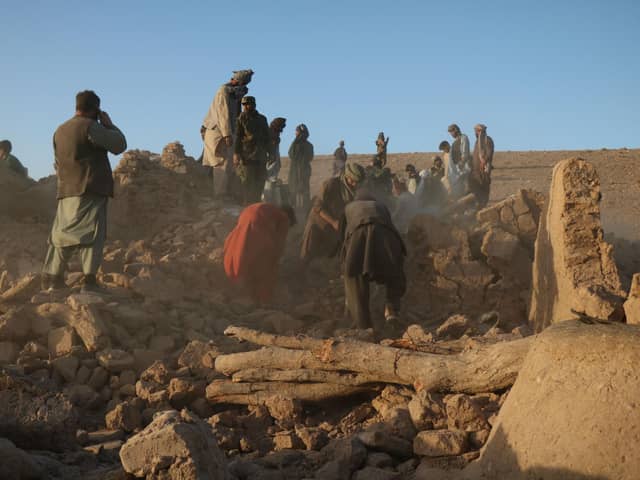 Afghan residents clear debris from a damaged house after earthquake in Sarbuland village of Zendeh Jan district of Herat province (Photo by Mohsen KARIMI / AFP) (Photo by MOHSEN KARIMI/AFP via Getty Images)