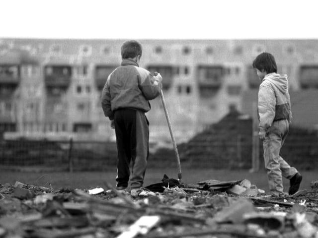 Two little boys playing in the rubble left after the old flats at West Granton were demolished, December 1992.