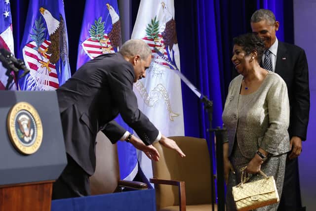 Outgoing US Attorney General Eric Holder bows to Aretha Franklin as she arrives unannounced with US President Barack Obama at the Justice Department in Washington in 2015 (Picture: Yuri Gripas/AFP via Getty Images)