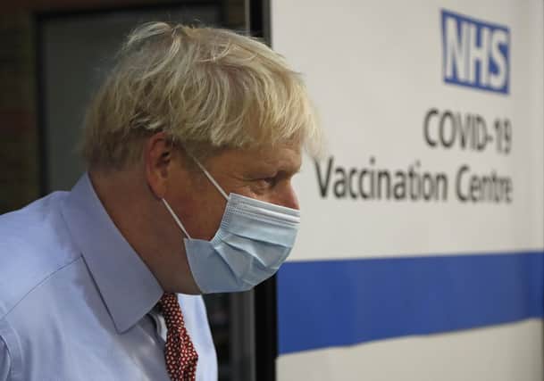 Prime Minister Boris Johnson looks on after nurse Rebecca Cathersides administered the Pfizer/BioNTech Covid-19 vaccine to Lyn Wheeler at Guy's Hospital in London.