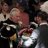 King Charles III is presented with the Crown of Scotland during the National Service of Thanksgiving and Dedication