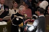 King Charles III is presented with the Crown of Scotland during the National Service of Thanksgiving and Dedication