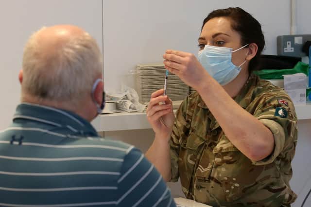 James Logan from Edinburgh, receives an injection of a coronavirus vaccine from military personnel who are assisting with the vaccination programme at the Royal Highland Showground near Edinburgh. Picture date: Thursday February 4, 2021.