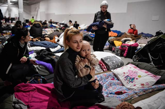 A young mother holds her baby in a temporary shelter for Ukrainian refugees near the Polish city of Przemysl (Picture: Louisa Gouliamaki/AFP via Getty Images)