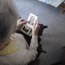 A woman suffering from Alzheimer's disease looks at an old picture (Picture: Sebastien Bozon/AFP via Getty Images)