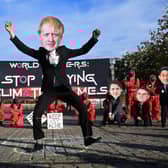 Climate change activists wearing masks depicting images of world leaders, including UK Prime Minister Boris Johnson, take part in a demonstration near the COP26 venue oin Glasgow on Monday
