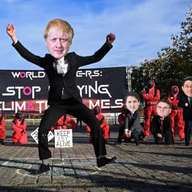 Climate change activists wearing masks depicting images of world leaders, including UK Prime Minister Boris Johnson, take part in a demonstration near the COP26 venue oin Glasgow on Monday