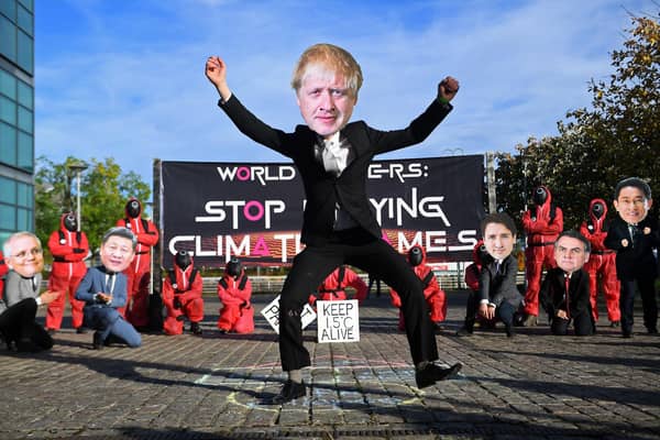 Climate change activists wearing masks depicting images of world leaders, including UK Prime Minister Boris Johnson, take part in a demonstration near the COP26 venue oin Glasgow on Monday
