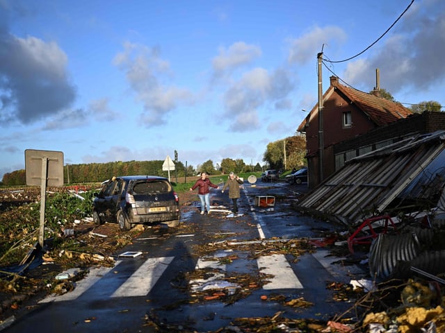 Local residents walk past a damages in Bihucourt, northern France, on October 24, 2022 after a tornado hit the region. (Photo by Sameer Al-Doumy / AFP)