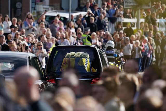 People gather in tribute as the cortege carrying the coffin of the late Queen passes through Banchory in Aberdeenshire