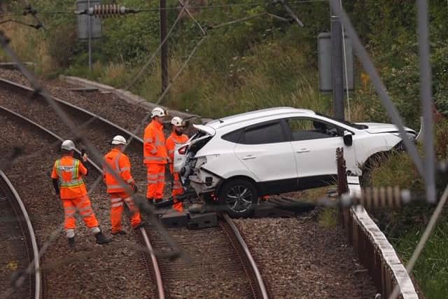 Rail workers recover the vehicle from the tracks. Pic: John Devlin.