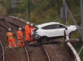Rail workers recover the vehicle from the tracks. Pic: John Devlin.