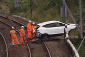 Rail workers recover the vehicle from the tracks. Pic: John Devlin.