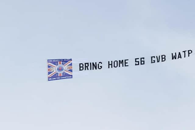A plane flies a banner overhead that reads 'Bring home 56 GVB WATP' during a cinch Premiership match between Rangers and Celtic at Ibrox.