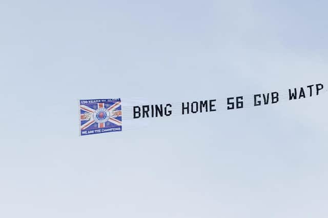 A plane flies a banner overhead that reads 'Bring home 56 GVB WATP'  during a cinch Premiership match between Rangers and Celtic at Ibrox.