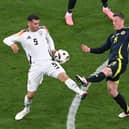 Scotland's Callum McGregor challenges with Germany's Pascal Gross during the Euro 2024 opener in Munich. (Photo by THOMAS KIENZLE/AFP via Getty Images)