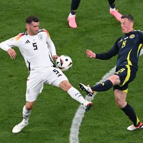 Scotland's Callum McGregor challenges with Germany's Pascal Gross during the Euro 2024 opener in Munich. (Photo by THOMAS KIENZLE/AFP via Getty Images)