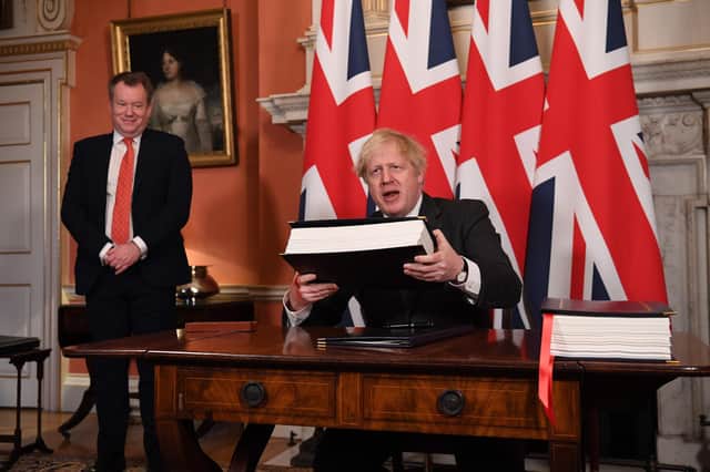UK chief trade negotiator, David Frost, looks on as Boris Johnson holds up the the Trade and Cooperation Agreement between the UK and the EU as he signed it at Downing Street on December 30 (Picture: Leon Neal/pool/AFP via Getty Images)