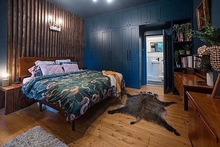 Wood panelling and flooring features prominently in the master bedroom.