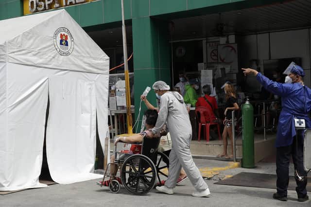 A Covid-19 patient is taken to an isolation tent outside a hospital in Manila, Philippines (Picture: Aaron Favila/AP)
