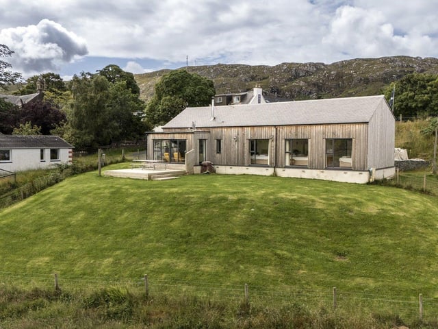 The property is on raised ground and the garden is mainly lawn.