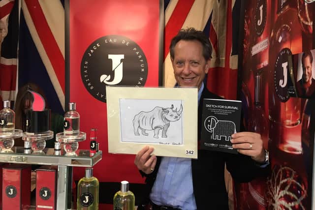 Actor Richard E Grant shows off the rhino drawing he created for a previous Sketch for Survival auction