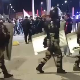 This picture taken from video footage posted on the Telegram channel @askrasul shows law enforcement personnel marching past as protestors gather at an airport in Makhachkala, Russia, where a mob looking for Israelis and Jews gathered after rumours spread that a flight was arriving from Israel.