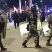 This picture taken from video footage posted on the Telegram channel @askrasul shows law enforcement personnel marching past as protestors gather at an airport in Makhachkala, Russia, where a mob looking for Israelis and Jews gathered after rumours spread that a flight was arriving from Israel.