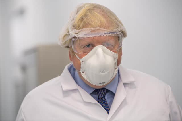 Britain's Prime Minister Boris Johnson visits the French biotechnology laboratory Valneva in Livingston, west Scotland, today after dismissing Germany's stance on not recommending the Astrazeneca jab to over 65's (Photo by Wattie Cheung / POOL / AFP).